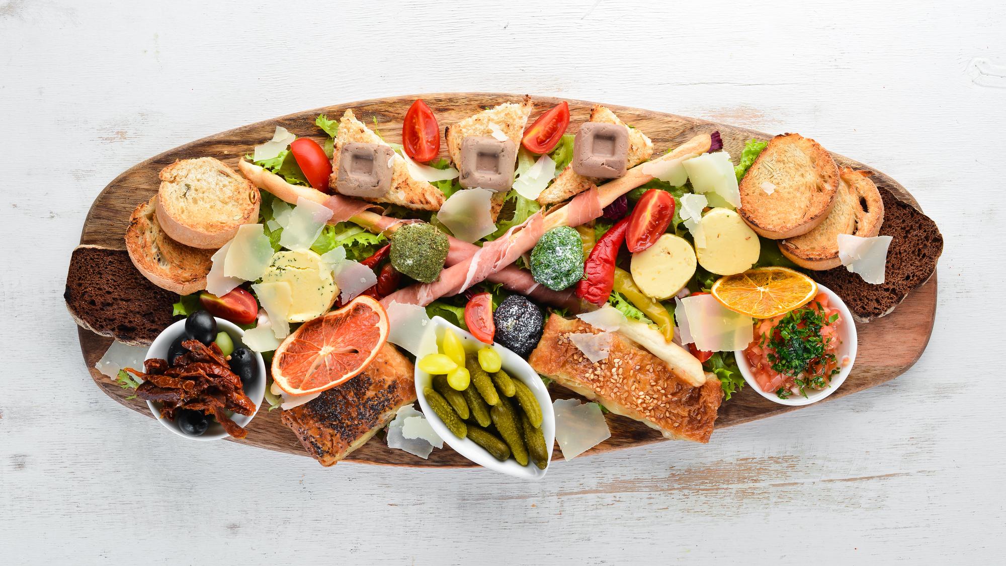 Assorted plated appetizers on wooden board
